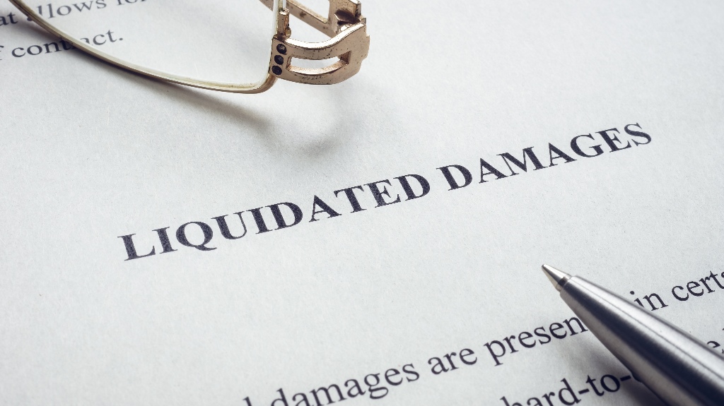 Documents about Liquidated damages with pen and glasses