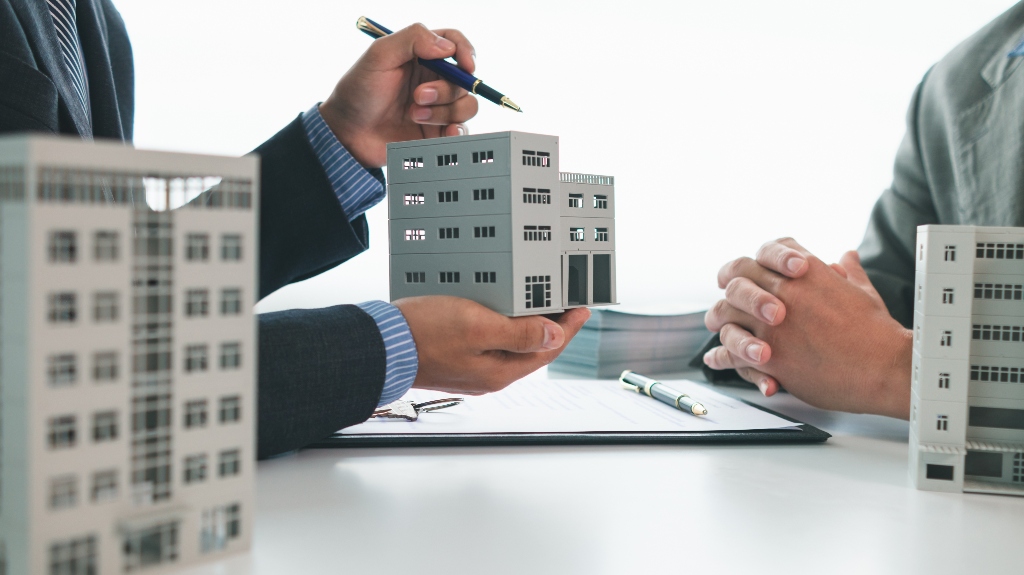 man is showing house model and documents